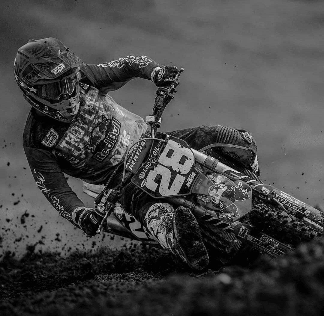 Piloto de motocross contornando uma curva na pista